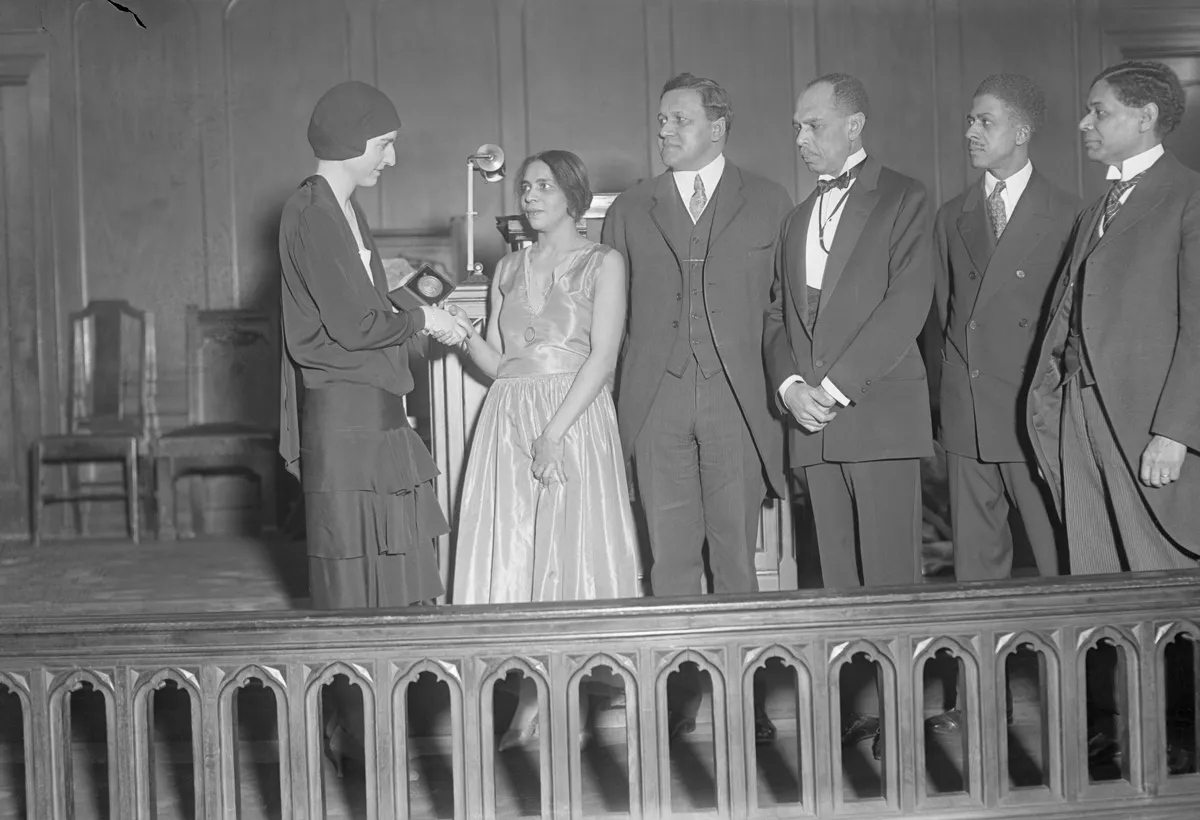 Miss Harmon, daughter of the founder, congratulating winners of the William E. Harmon Foundation Award for Distinguished Achievement among Negroes, at the Zion church, 1928. Collecting awards are (left to right) Nella Larsen imes, Channing H. Tobias, James Weldon Johnson (collecting the award on behalf of Claude McKay), unknown. At far right is Dr. George Haynes, secretary of committee on race relations. (Photo by UPI/Bettmann Archive/Getty Images)