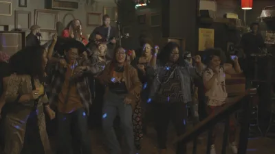 A group of people dancing in a darkened room.