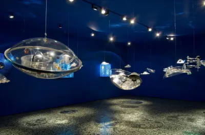 A group of floating Plexiglas disks set within in a blue gallery.