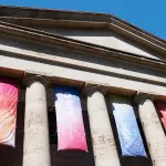 A columned building with banners between its columns.