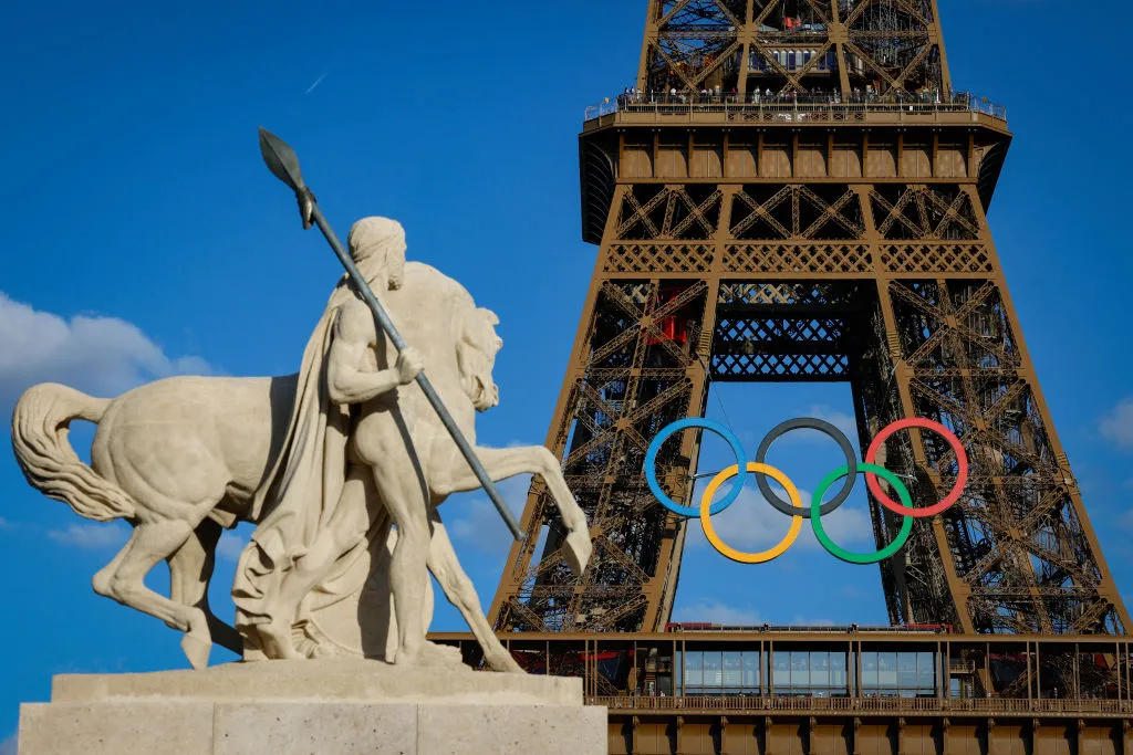 Olympic rings are seen on the Eiffel Tower near the restored statue of "Cavalier Arabe" (Arab rider) on the Pont d