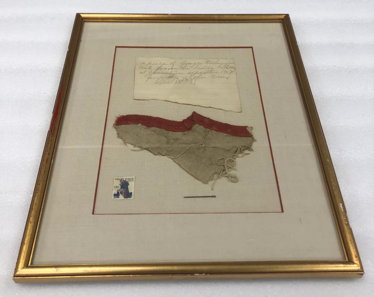 A framed sliver of red trimmed canvas from a tent belonging to George Washington.