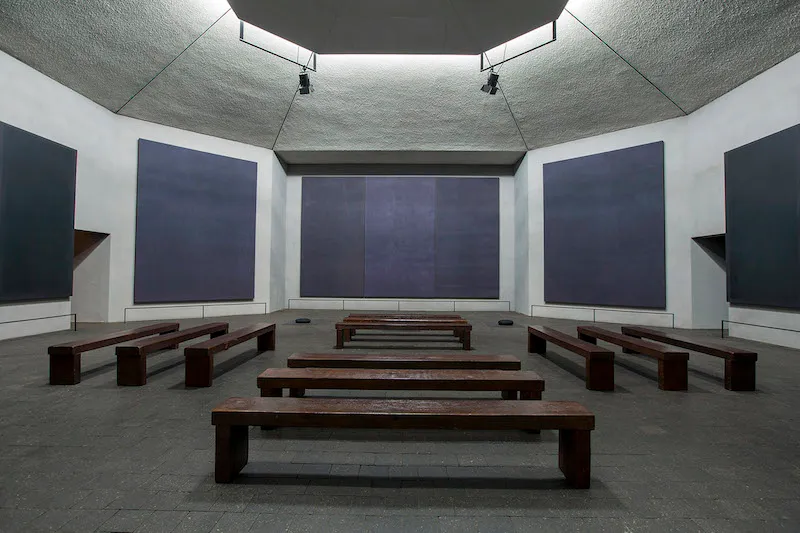 Five dark paintings in a chapel-like setting.