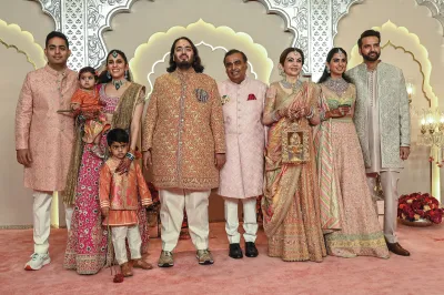 TOPSHOT - Billionaire tycoon and Chairman of Reliance Industries Mukesh Ambani (C) with his wife Nita Ambani (3R), daughter Isha Ambani (2R), sons Akash Ambani (L) and Anant Ambani (C, left), daughter-in-law Shloka Mehta (2L), and son-in-law Anand Piramal pose for photos as they arrive to attend the wedding ceremony of Anant and Radhika Merchant in Mumbai on July 12, 2024. Socialite sisters Kim and Khloe Kardashian were among the global celebrities spotted in India on July 12 to attend a lavish three-day wedding ceremony staged by Asia