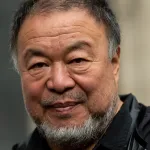 A close-up shot of the artist Ai Weiwei smiling.