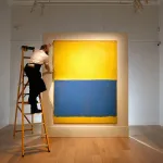 LONDON, ENGLAND - APRIL 10: A gallery technician makes adjustments to the hanging of Mark Rothko