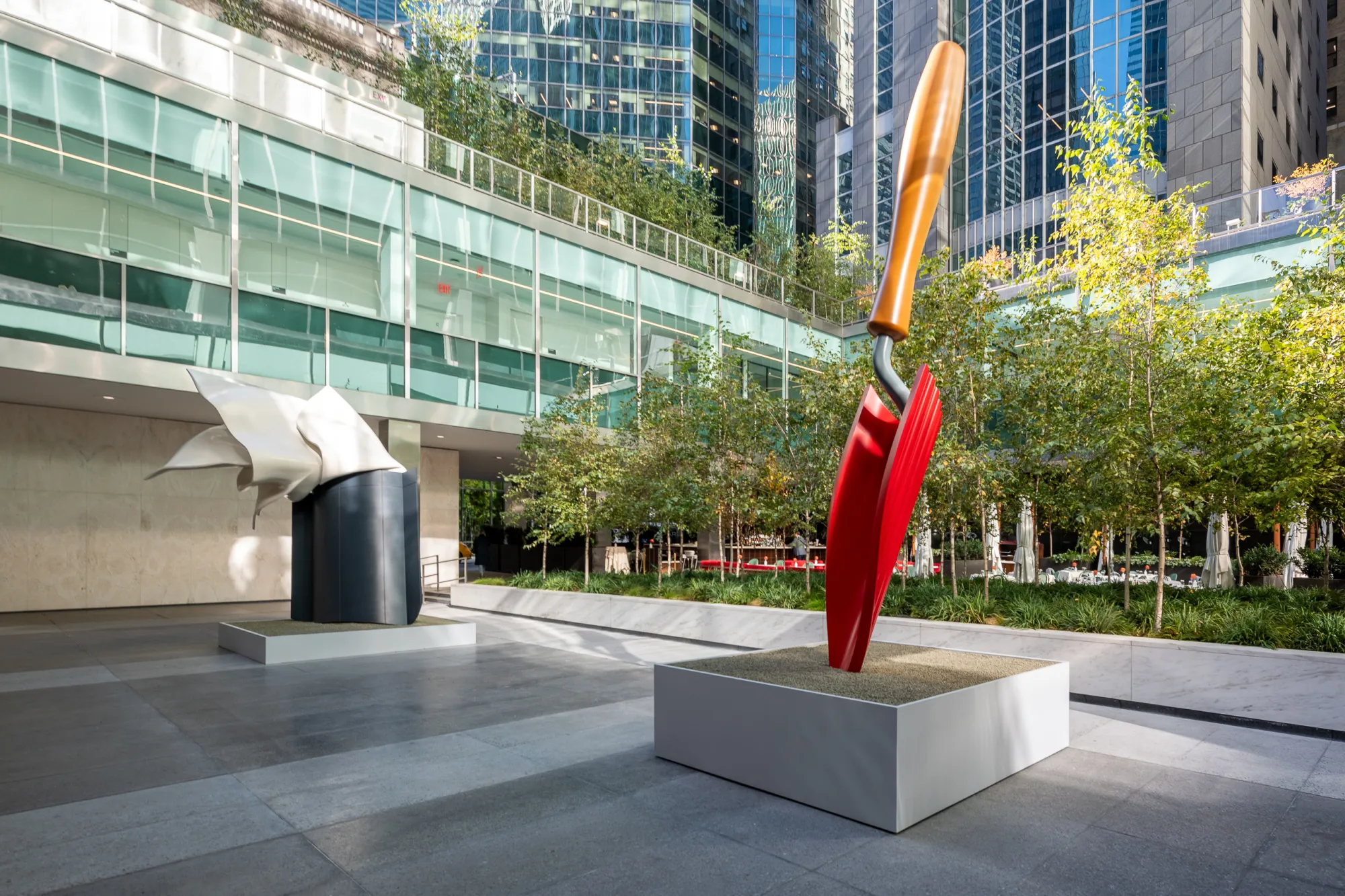 Monumental sculptures of a red garden trowel and a handkerchief.