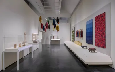 A gallery with textiles hanging on its walls and from its ceiling.