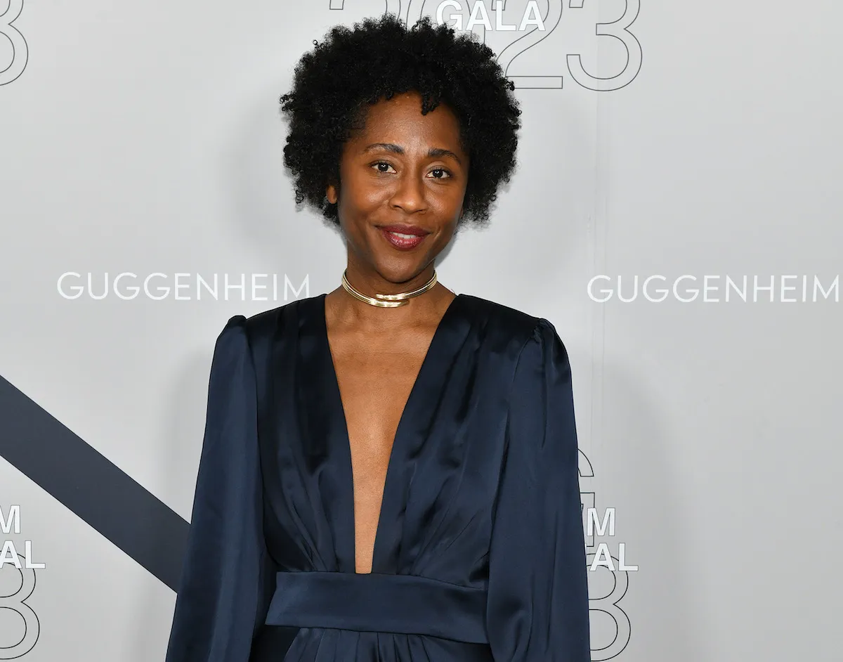 A Black woman in a blue dress on a red carpet.