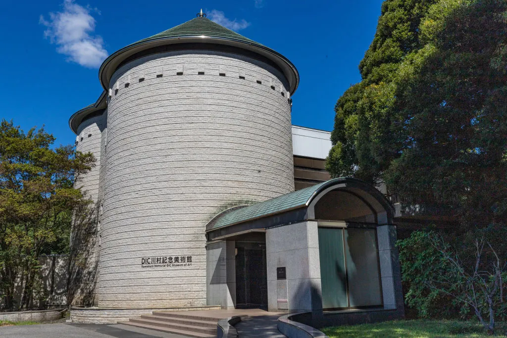 A cylindrical shaped tower with an entrance jutting out.