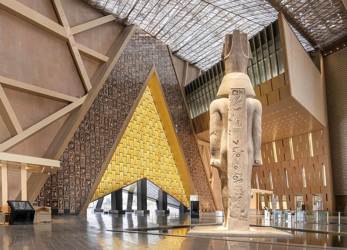 A large atrium dominated by a tall Egyptian statue and a triangular entryway.