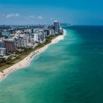 Aerial view of South Beach Miami Florida cityscape with buildings along the beach on a beautiful sunny day, people on beach and ocean