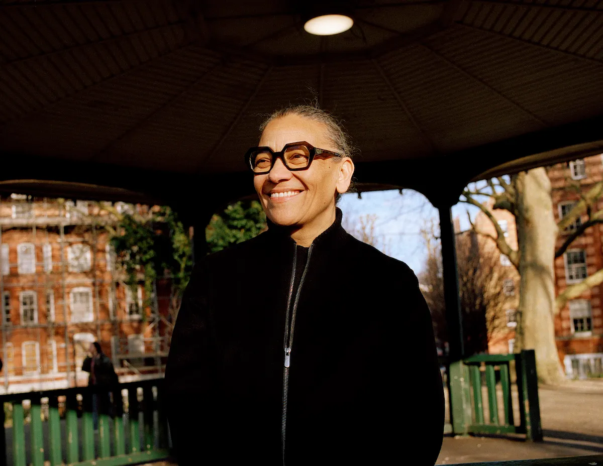 A smiling Black woman in a park.