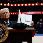 WASHINGTON, DC - JANUARY 20: U.S. President Donald Trump holds up an executive order after signing it during an indoor inauguration parade at Capital One Arena on January 20, 2025 in Washington, DC. Donald Trump takes office for his second term as the 47th president of the United States. (Photo by Anna Moneymaker/Getty Images)