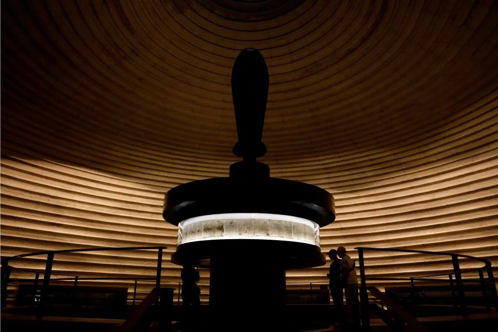 TOPSHOT - Men look at the Dead Sea Scrolls found in Qumran caves in the Judean Desert and dated around 120 BC, during a visit to the Shrine of the Book at at the Israel Museum on May 2, 2018 in Jerusalem. - The Dead Sea Scrolls are a collection of hundreds of biblical texts in Hebrew, Aramaic, and Greek discovered 45 years ago in the Qumran Caves near the Dead Sea. (Photo by GALI TIBBON / AFP) (Photo by GALI TIBBON/AFP via Getty Images)